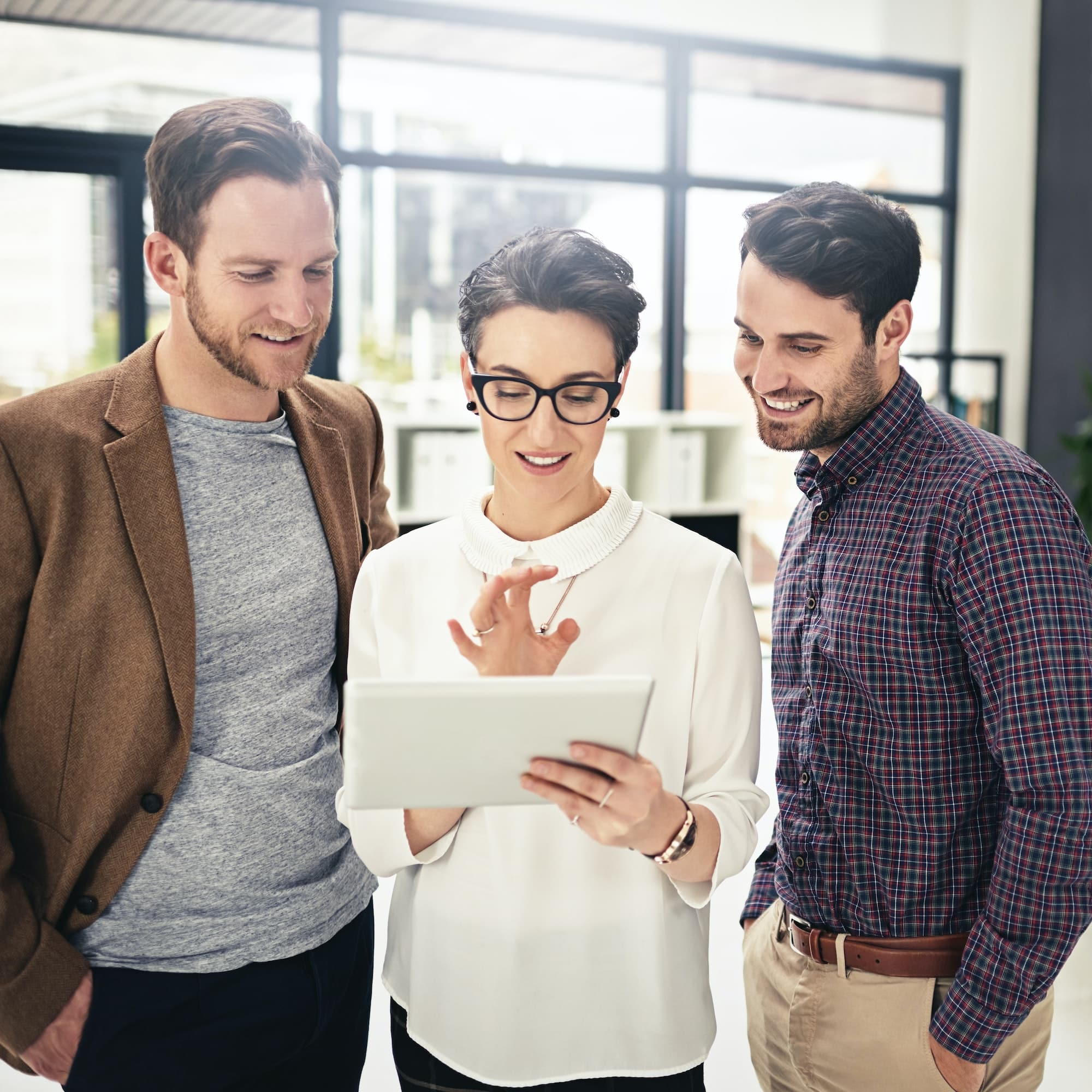 Shot of a team of businesspeople discussing something on a digital tablet