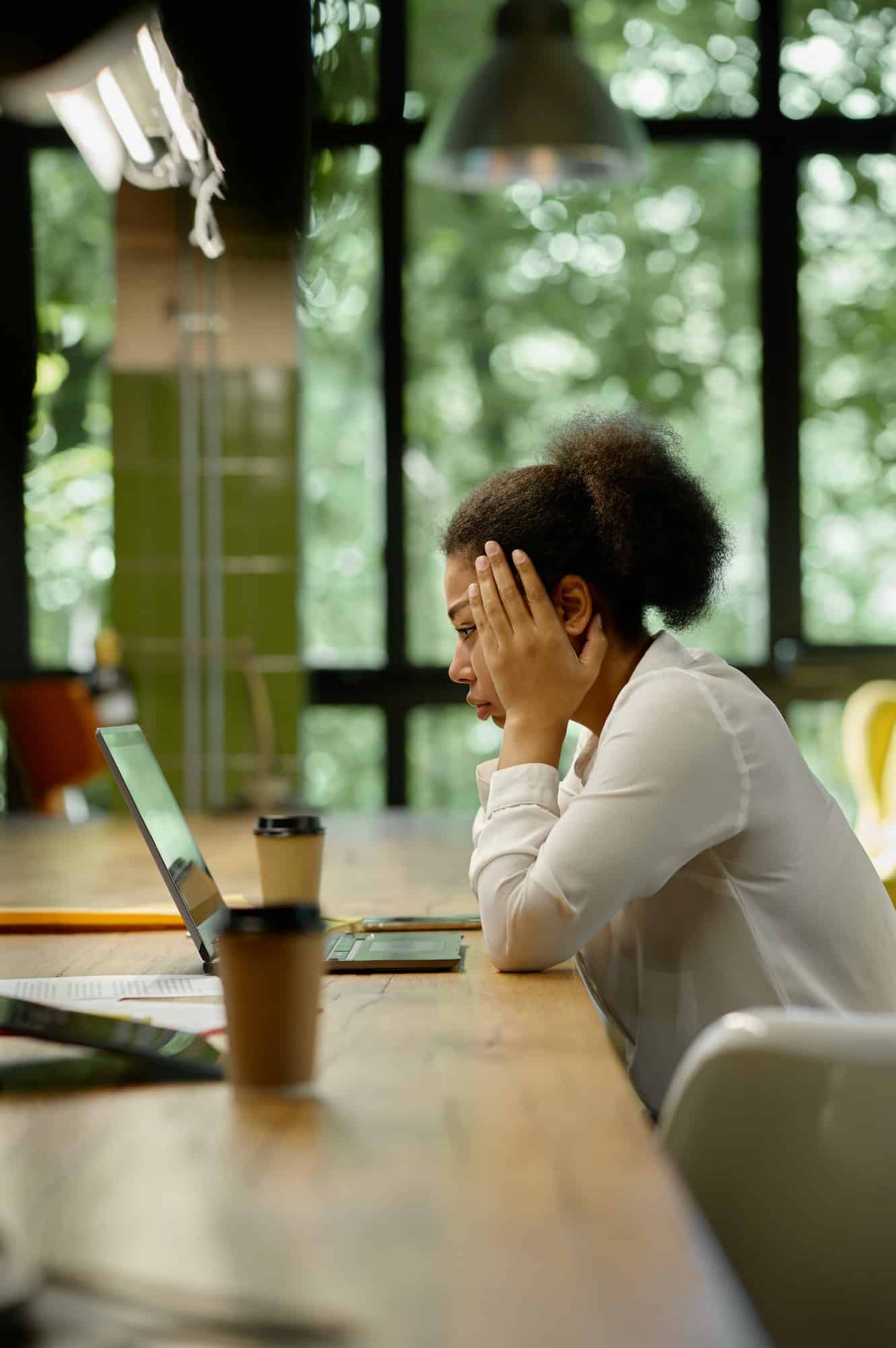 Shocked worried business woman looking at laptop sitting in office